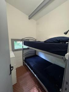 two bunk beds in a room with a window at Le Souffle des Cévennes in Saint-Étienne-Vallée-Française