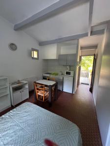a kitchen with a bed and a table in a room at Le Souffle des Cévennes in Saint-Étienne-Vallée-Française