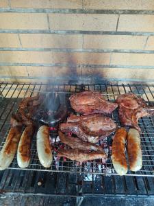 a bunch of meats and sausages on a grill at Studio in Barbéns, Miranda do Corvo - Casa 99 in Miranda do Corvo