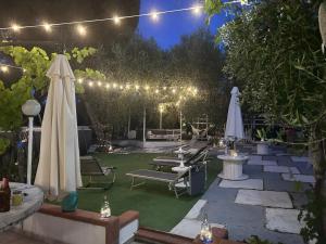 a patio with chairs and umbrellas at night at Muschiaturo in Foce Varano