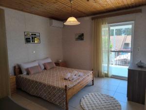 a bedroom with a bed and a large window at Afroditi Country Residence in Oropos
