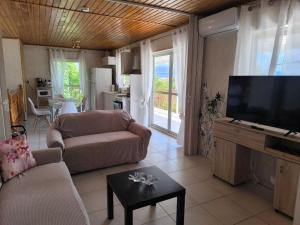 a living room with a couch and a flat screen tv at Afroditi Country Residence in Oropos