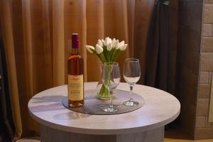 a bottle of wine and two glasses on a table at Durmitorski san in Žabljak