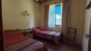 a hotel room with two beds and a window at Complejo Don Antonio in San Agustín de Valle Fértil +24 photos