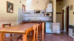 a kitchen with a wooden table with chairs and a tableablish at Complejo Don Antonio in San Agustín de Valle Fértil