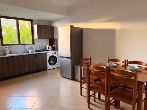 a kitchen with a table and a kitchen with a refrigerator at Portside Living in Sarandë