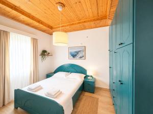a bedroom with a blue bed and a wooden ceiling at Portside Living in Sarandë