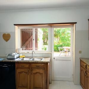 a kitchen with a sink and a sliding glass door at Concha de Moledo in Moledo