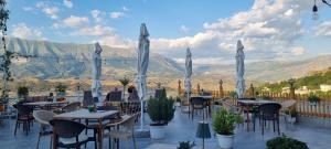 a restaurant with tables and chairs with mountains in the background at Guest House Juald in Gjirokastër