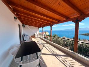 a balcony with a table and chairs and the ocean at Portside Living in Sarandë