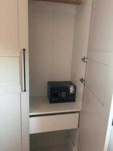 a small microwave sitting on a shelf in a closet at Linen Sea Halkidiki in Kriopigi
