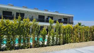 a resort with a row of trees in front of a building at Linen Sea Halkidiki in Kriopigi
