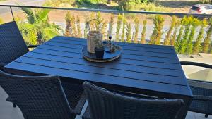 a blue table on a balcony with two chairs at Linen Sea Halkidiki in Kriopigi
