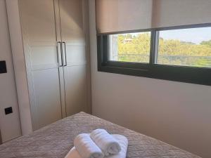 two towels on a bed in a room with a window at Linen Sea Halkidiki in Kriopigi +31 photos