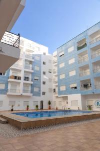 an apartment building with a swimming pool in front of it at Apartamento de lujo Martil in Martil