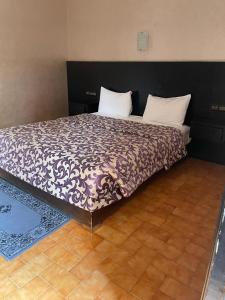 a bedroom with a bed with a purple and white comforter at Hôtel Résidence Marrakech in Marrakesh +11 photos