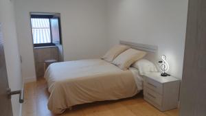 a bedroom with a bed and a lamp on a night stand at Casa Ataraxia II in Boiro
