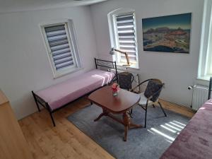 a bedroom with a bed and a table and window at Pension La Familia in Löbau