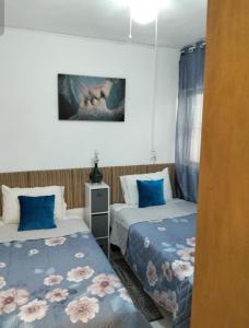 a room with two beds with blue pillows at departamento bugambilias in Tepic