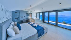 a bedroom with a large bed and large windows at Villa Infinity Sky - Private Pool - Panoramic Sea View in Kaş +51 photos