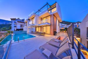 a house with a swimming pool and some chairs at Villa Infinity Sky - Private Pool - Panoramic Sea View in Kaş