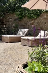 two beds and an umbrella in a garden at Stamping Cottage Studio Between St Ives & Penzance in Penzance
