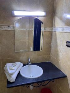 a bathroom with a sink and a mirror at Hôtel Résidence Marrakech in Marrakesh