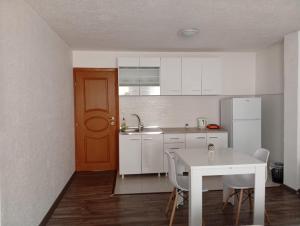 a kitchen with a white table and a white refrigerator at Guest house Erdan in Plav
