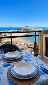 a table with plates and wine glasses on a balcony at Marina suite in Peniscola