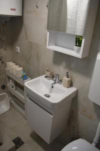 a bathroom with a white sink and a toilet at Durmitorski san in Žabljak +15 photos