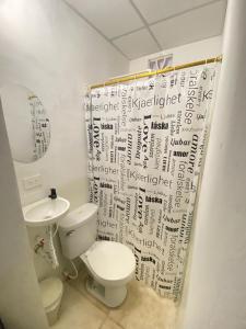 a bathroom with a toilet and a sink with a shower curtain at Perez Leal in San Antonio del Táchira +8 photos