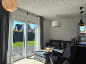 a living room with a couch and a window at Moderne Ferienwohnung mit Sauna & Terrasse in Burhave