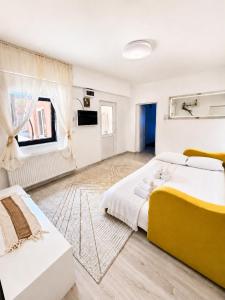 a large bedroom with a yellow bed and a window at Casa Family in Eforie Sud