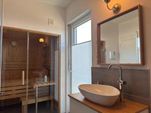 a bathroom with a sink and a mirror at Moderne Ferienwohnung mit Sauna & Terrasse in Burhave +23 photos