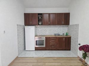 a kitchen with wooden cabinets and a white refrigerator at Vila Lana in Trebinje