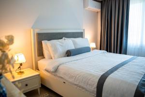 a bedroom with a large bed with white sheets and a window at Luna in Dalaman +6 photos