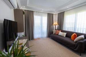 a living room with a couch and a flat screen tv at Luna in Dalaman