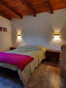 a bedroom with a bed and two lights on the wall at Tafi del Valle Casa Kabure in Tafí del Valle