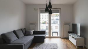 a living room with a couch and a tv at BEMO Apartment in Warsaw
