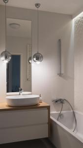 a bathroom with a sink and a tub and a mirror at BEMO Apartment in Warsaw +6 photos