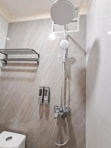 a shower in a bathroom with a toilet at Nafaka Hostel and Tours in Malang +28 photos