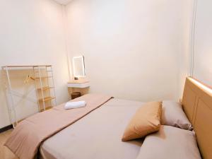 a small room with a bed and a tv at Nafaka Hostel and Tours in Malang