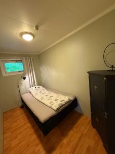 a small bedroom with a bed and a dresser at Cozy apartment with two bedrooms in Tromsø