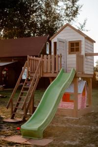 a playground with a slide and a play house at Nad Andruszkowianką in Andruszkowice