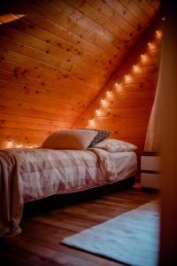 a bed in a wooden room with lights on it at Nad Andruszkowianką in Andruszkowice