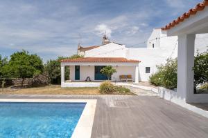 a white house and a swimming pool in front of a house at Casa do Loureiro in Alandroal