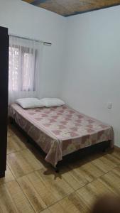 a bed sitting in a room with a window at Natural country house in Guarne