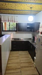 a kitchen with black cabinets and a white refrigerator at Natural country house in Guarne