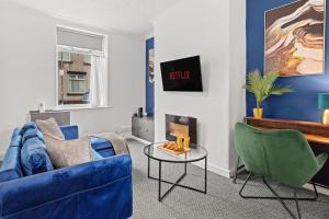 a living room with a blue couch and two green chairs at Haydock Contractor House, 2-Bed, Easy M6 Access in Haydock