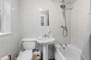 a white bathroom with a toilet and a sink at Haydock Contractor House, 2-Bed, Easy M6 Access in Haydock +14 photos